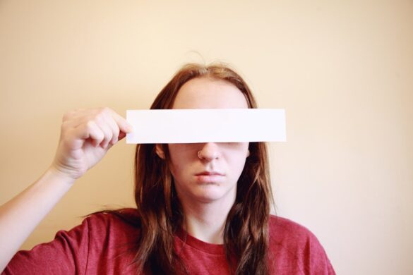 Young person hiding their eyes.